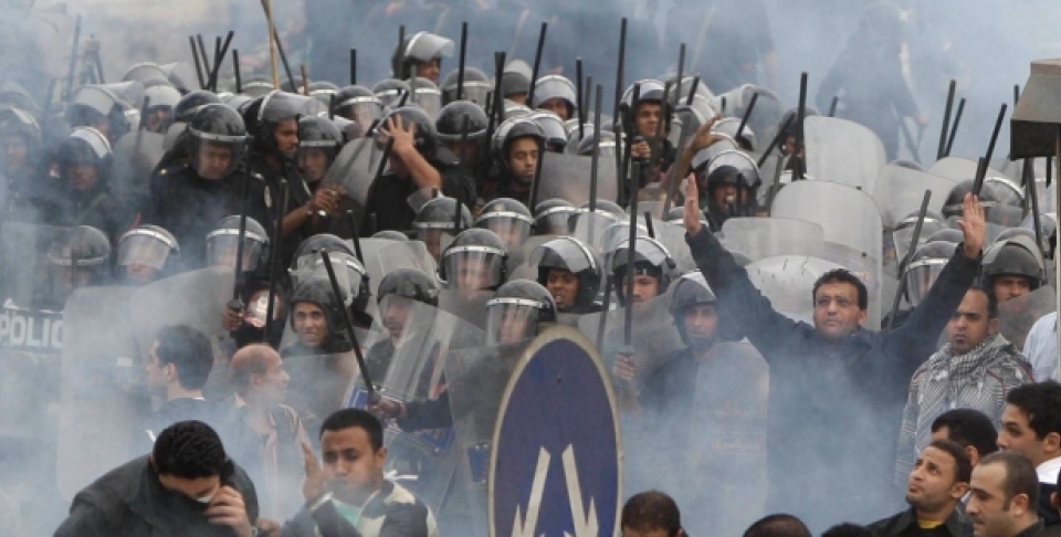 In this Jan. 28, 2011 photo, Egyptian anti-government activists clash with riot police in Cairo, Egypt. (AP Photo/Ben Curtis, File)