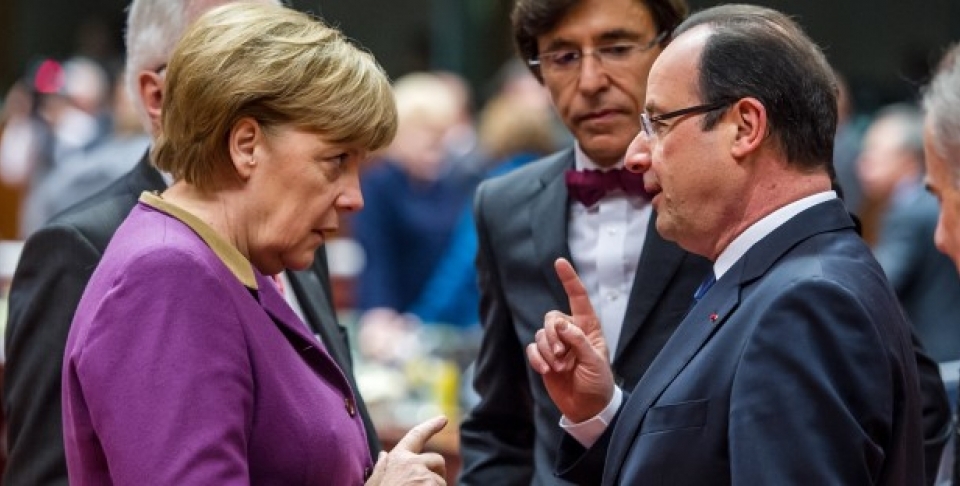 German Chancellor Angela Merkel speaks with French President Francois Hollande during a round table meeting at an EU summit in Brussels. (AP Photo/Geert Vanden Wijngaert)