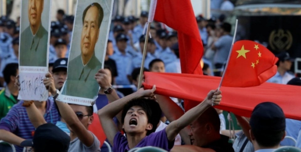 A Chinese man shouts anti-Japan slogans with Chinese national flags near portraits of the late Communist leader Mao Zedong in front of the Japanese Embassy in Beijing, September 2012. (AP Photo/Ng Han Guan)