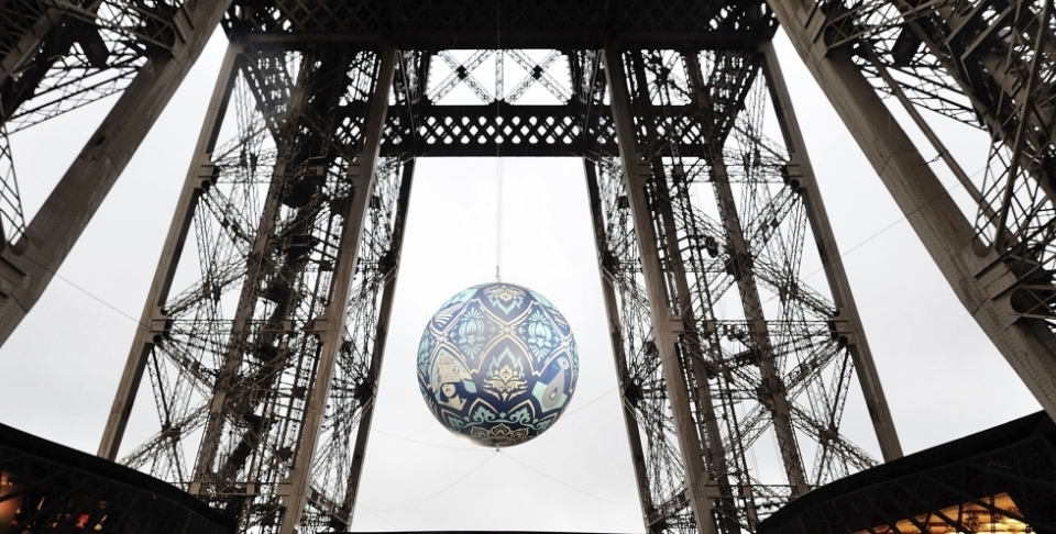American street artist Shepard Fairey, aka Obey's piece 'Earth Crisis', a giant sphere themed on environment hangs between the first and second floor of the Eiffel Tower in Paris on Nov. 20, 2015. The piece was on display leading up to the 2015 climate change conference. (AP Photo/Binta Epelly)