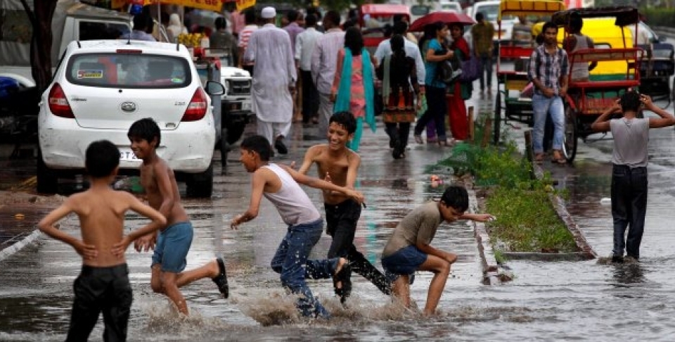 Children play in a water puddle left after a spell of rain in New Delhi, India. (AP Photo/Saurabh Das)