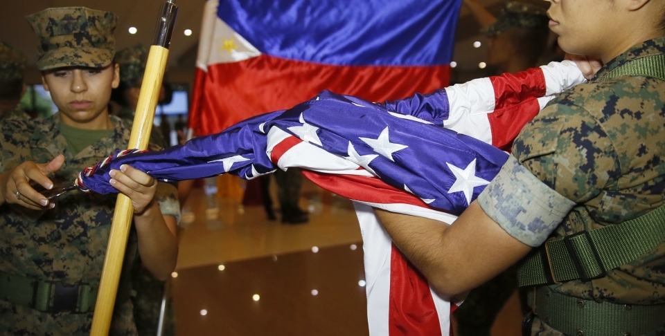 A U.S. Marine and her Philippine counterpart fold their flags near Manila on Oct. 11. Marines ended joint combat drills a day early after President Rodrigo Duterte criticized the U.S. (AP Photo/Bullit Marquez)