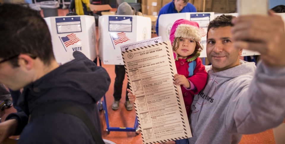 A man takes a selfie with his child as he waits to vote at a polling station in Brooklyn borough of New York on Tuesday, Nov. 8, 2016. (AP Photo/Alexander F. Yuan)