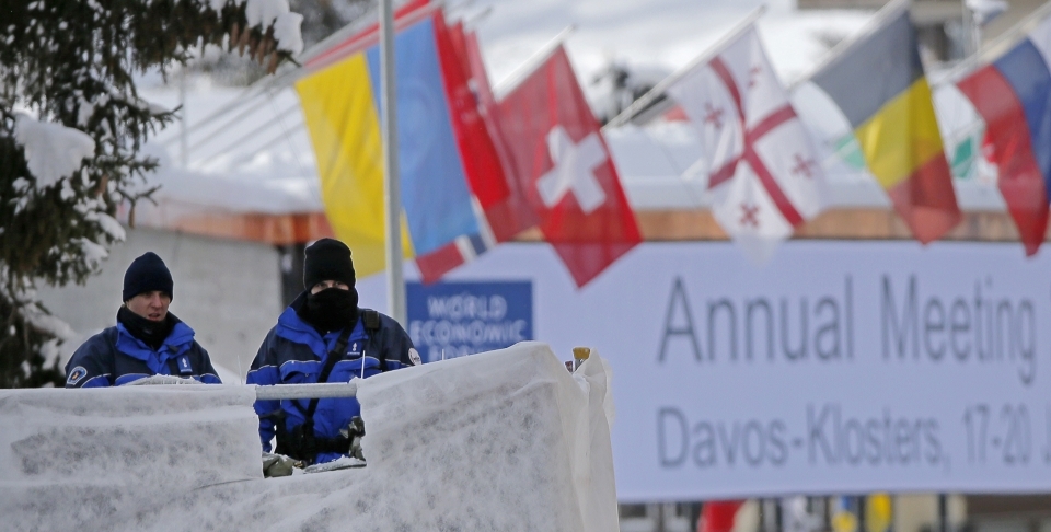 Swiss police officers guard the entrance to the World Economic Forum in Davos, Switzerland (AP Photo/Michel Euler)
