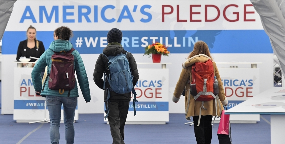 Visitors enter the US Climate Action Center at the COP 23 Fiji UN Climate Change Conference in Bonn, Germany, Thursday, Nov. 9, 2017. (AP Photo/Martin Meissner)
