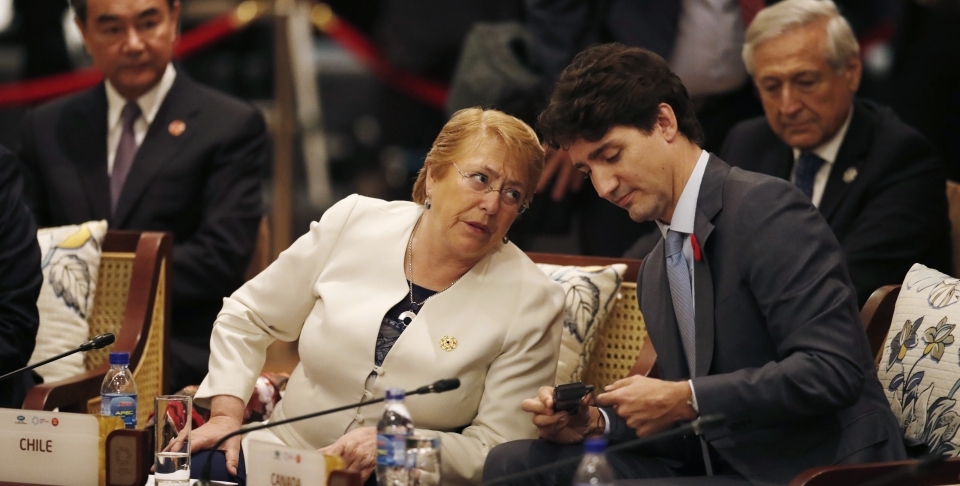 Prime Minister Justin Trudeau speaks with Chile's former president, Michelle Bachelet; both leaders have championed gender-considerate trade pacts. (Jorge Silva/AP Photo)