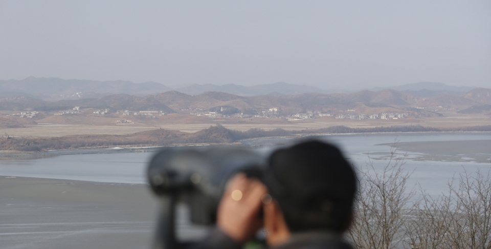 A visitor uses binoculars to see North Korea from the unification observatory in Paju, South Korea, Monday, January 1, 2018. (AP Photo/Lee Jin-man)