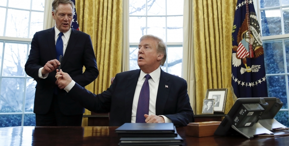 President Donald Trump, hands the pen he used to sign Section 201 actions to US Trade Representative Robert Lighthizer. (AP Photo/Carolyn Kaster)