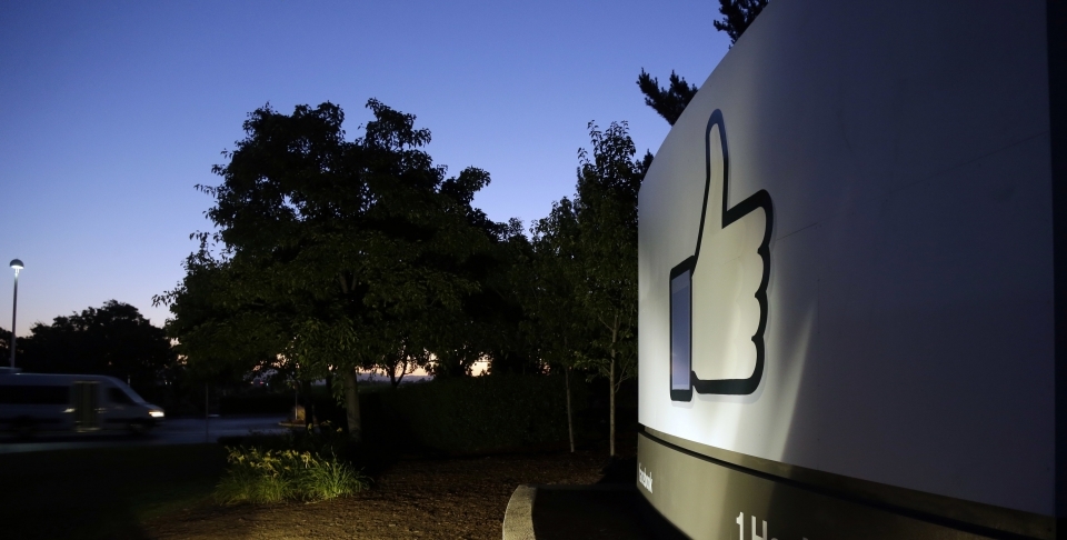 The Facebook "like" symbol is illuminated on a sign outside the company's headquarters in California. (AP Photo/Marcio Jose Sanchez)