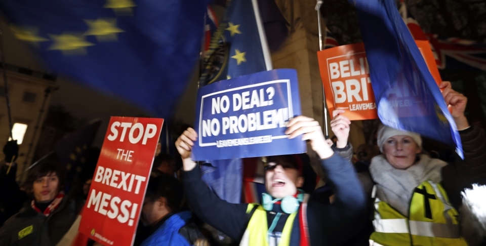 Protestors hold signs in Parliament Square in London, Tuesday, January 15, 2019. (AP Photo/Frank Augstein)