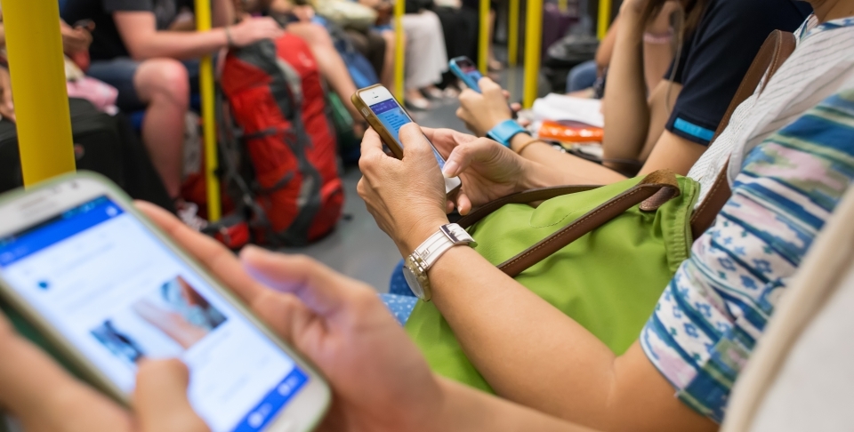 Unknown people uses mobile phone while travel by subway. (Shutterstock)