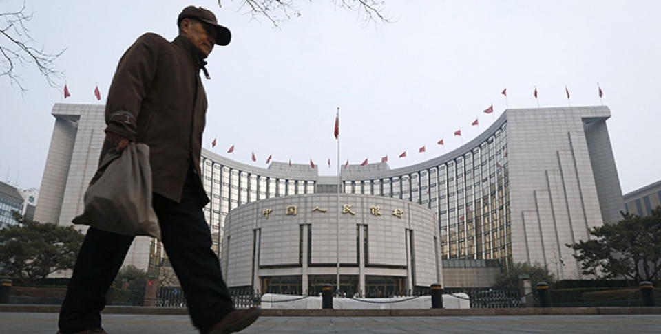 An elderly Chinese man walks past the headquarters of the People's Bank of China (PBOC) in Beijing, China. (AP Photo/Vincent Thian)