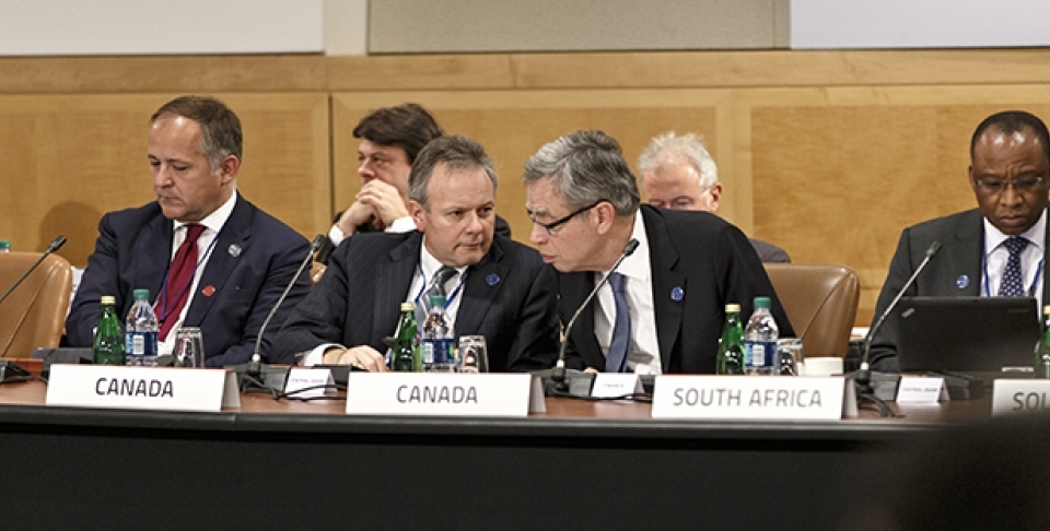 Canada's Minister of Finance Joe Oliver, center right, leans in to speak with Stephen Poloz, governor of the Bank of Canada, center left, as the Group of Twenty nations gather at the International Monetary Fund and World Bank meetings in Washington. (AP Photo/J. Scott Applewhite)