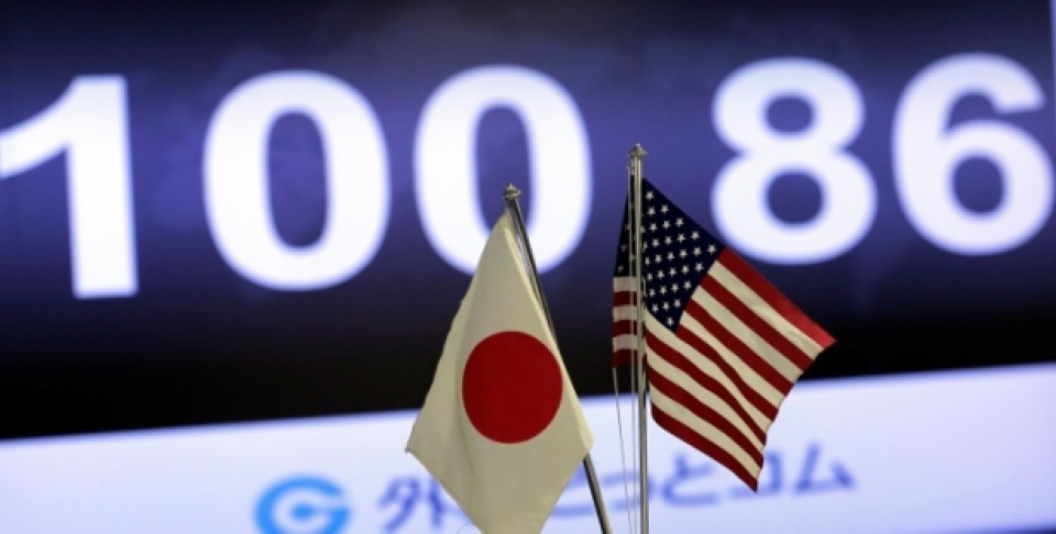 The exchange rate of the U.S. dollar against Japanese yen is shown behind both countries' flags at an exchange in Tokyo, Friday, May 10, 2013. The yen broke the the psychologically important 100 yen to the dollar mark. (AP Photo/Itsuo Inouye)
