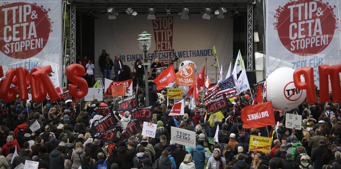 Protesters gather in front of the main stage during a demonstration of thousands of people against the planned Transatlantic Trade and Investment Partnership, TTIP, and the Comprehensive Economic and Trade Agreement, CETA, ahead of the visit of US President Barack Obama in Hannover, Germany, Saturday, April 23, 2016. (AP Photo/Markus Schreiber)