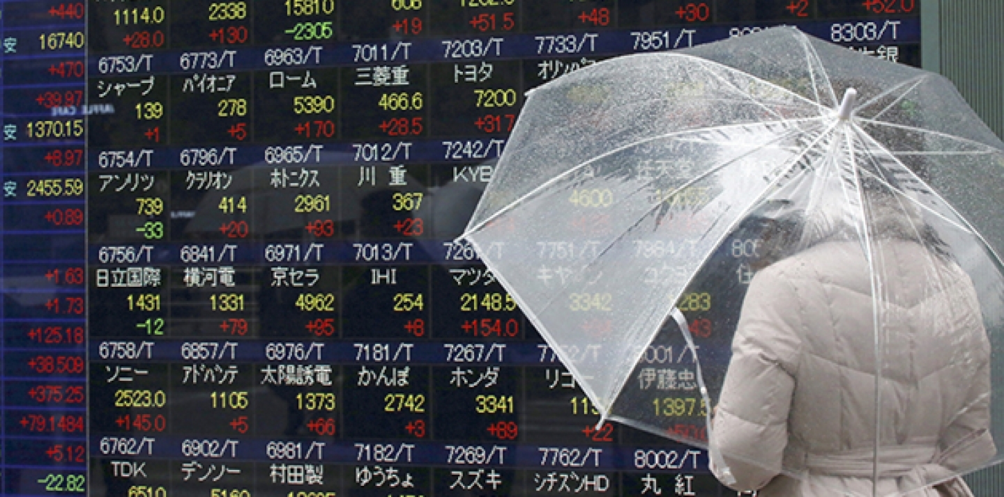 A woman looks at an electronic stock board at a securities firm in Tokyo, Friday, Jan. 29, 2016. Tokyo stocks finished nearly 3 percent higher on Friday while the yen dived as the country's central bank introduced a negative interest rate policy to boost the economy after previous stimulus efforts produced indifferent results. (AP Photo/Eugene Hoshiko)