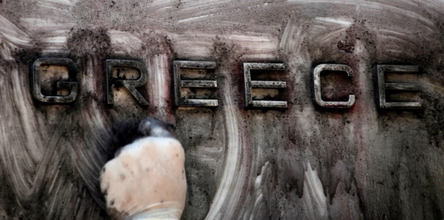 A worker cleans the paint-splattered entrance of the Bank of Greece, in central Athens Thursday, Sept. 15, 2011. (AP Photo/Petros Giannakouris)