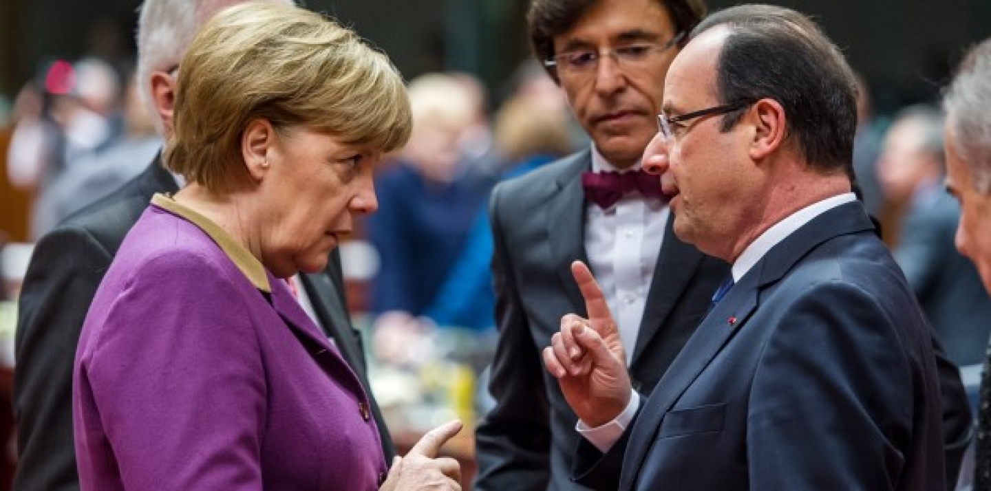 German Chancellor Angela Merkel speaks with French President Francois Hollande during a round table meeting at an EU summit in Brussels. (AP Photo/Geert Vanden Wijngaert)