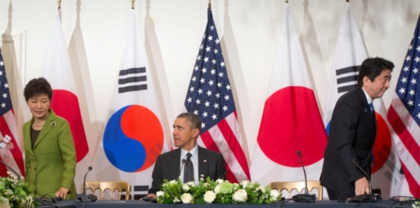 President Barack Obama watches as South Korean President Park Geun-hye, left, and Japanese Prime Minister Shinzo Abe, leave their seats, March 25, 2014, during the start of their trilateral meeting at the US Ambassador's Residence in the Hague, Netherlands. (AP Photo/Pablo Martinez Monsivais)