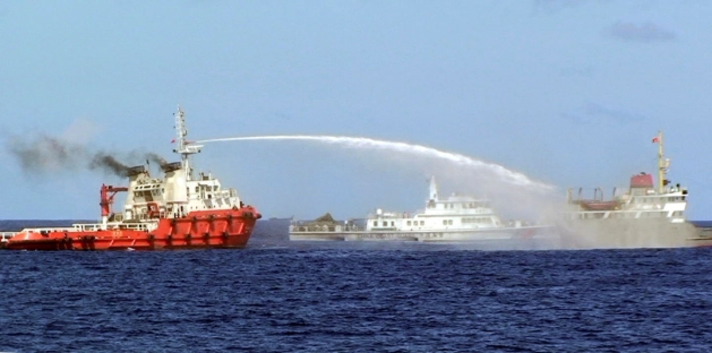 A Chinese ship shoots water cannon at a Vietnamese vessel, while a Chinese Coast Guard ship, center, sails alongside in the South China Sea, off Vietnam's coast, May 7, 2014. Chinese ships are ramming and spraying water cannons at Vietnamese vessels trying to stop Beijing from setting up an oil rig in the South China Sea, according to Vietnamese officials (AP Photo/Vietnam Coast Guard).