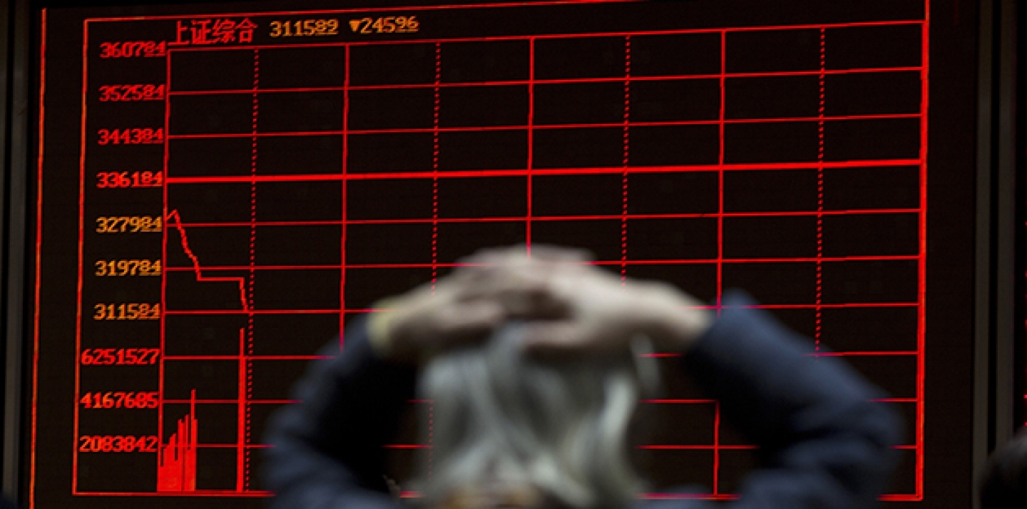A woman reacts near a display board showing the plunge in the Shanghai Composite Index at a brokerage in Beijing, China, on January 7, 2016. (AP Photo/Ng Han Guan, File)