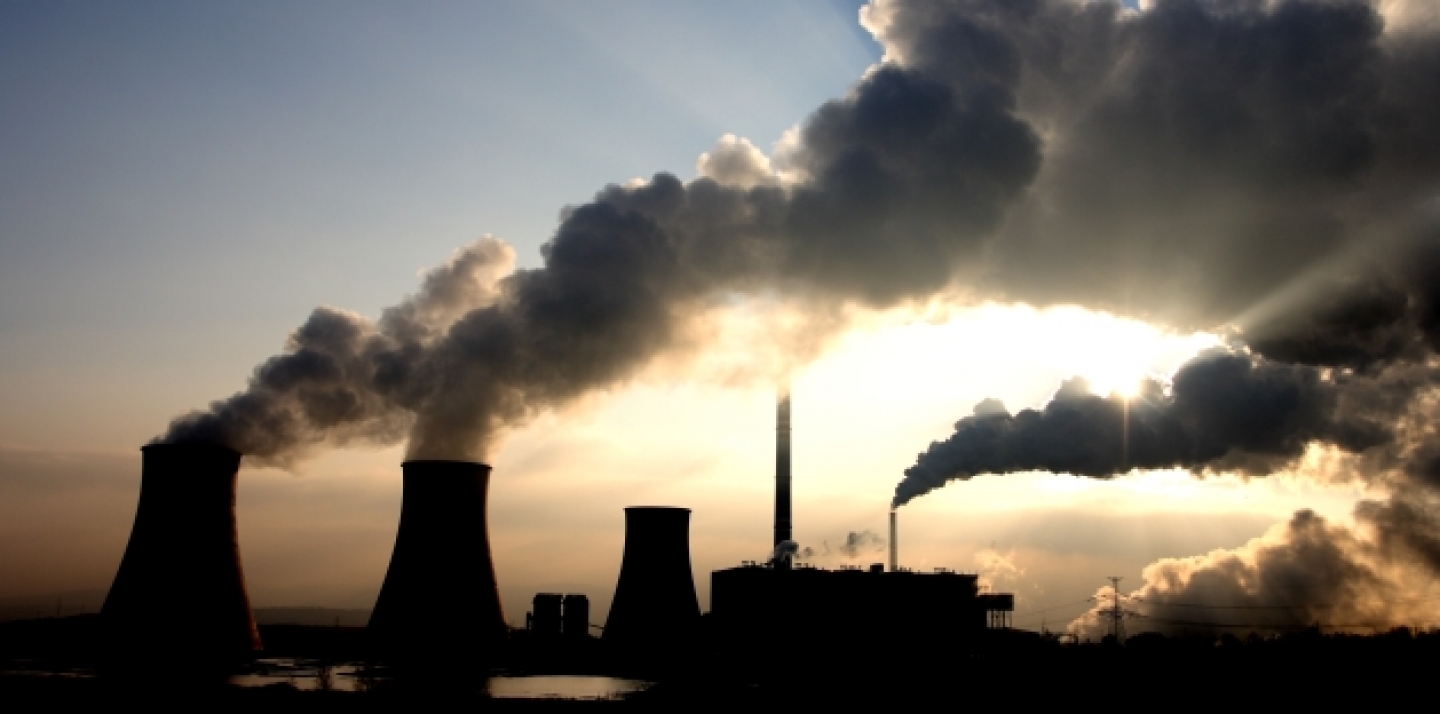 View of a coal power plant against sun. (Shutterstock)