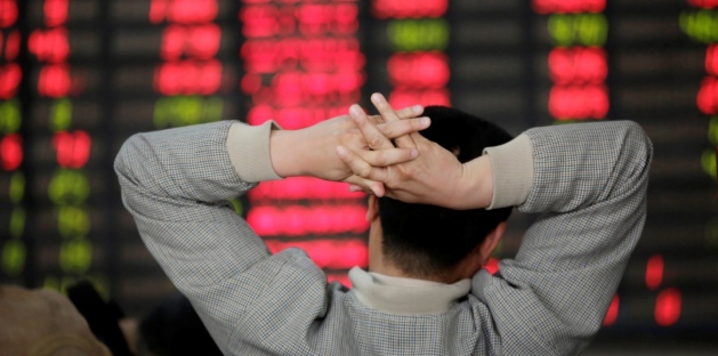 An investor looks at the stock price monitor at a private securities company in Shanghai, China Monday, April 8, 2013. (AP Photo/Eugene Hoshiko)