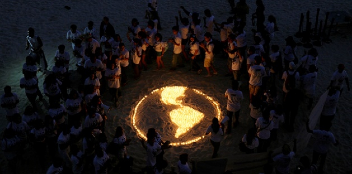 A group stands around a map made of candles during an event held alongside the United Nations Climate Change Conference. (AP Photo/Eduardo Verdugo)