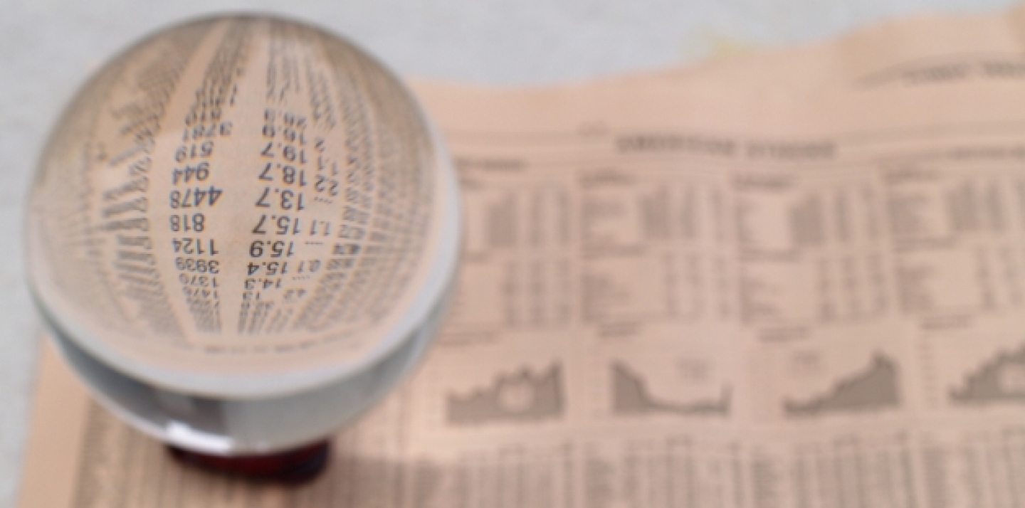 A crystal ball sits on the financial section of a newspaper (Shutterstock).