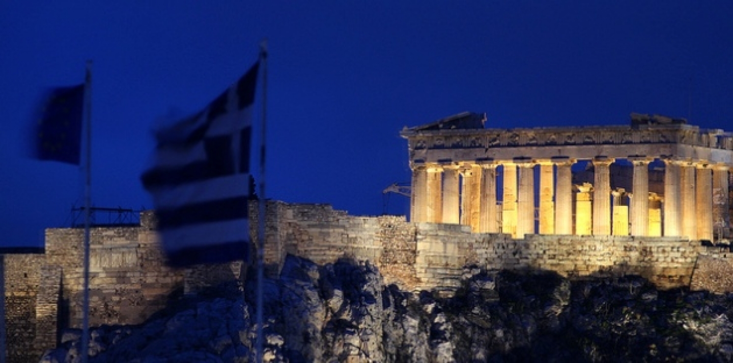 The flags of Greece and European Union flutter from the roof of the Finance Minister with the ancient Parthenon temple in Athens behind (AP Photo/Dimitris Messinis).