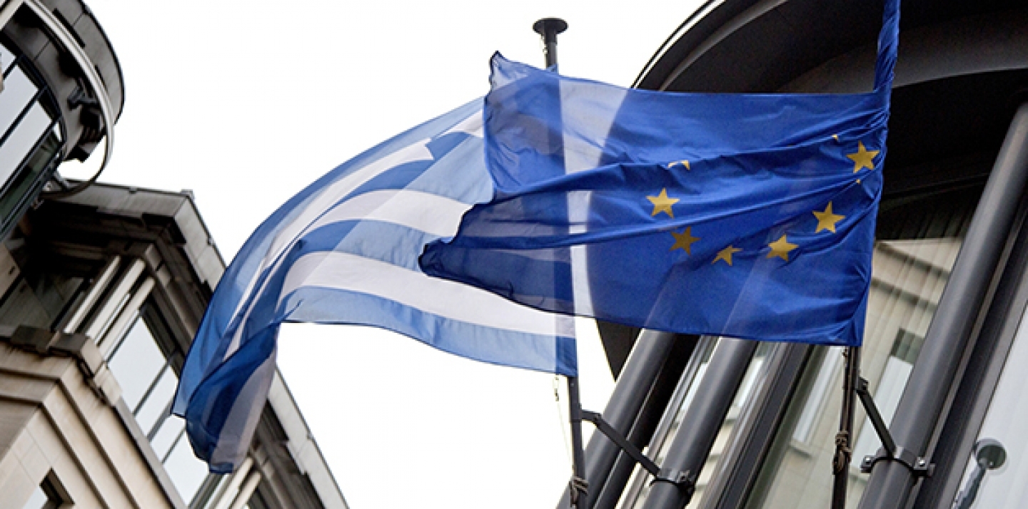 The Greek, left, and EU flag flap in the wind outside the Greek embassy in Brussels. (AP Photo/Virginia Mayo)