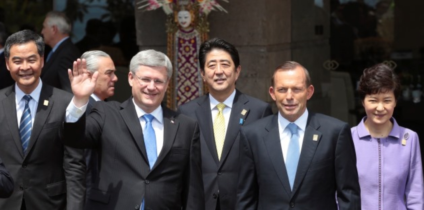 Canadian Prime Minister Stephen Harper waves as he stands with other leaders of the Asia-Pacific region for a group photo session during the Asia-Pacific Economic Cooperation (APEC) forum. (AP Photo/Dita Alangkara)