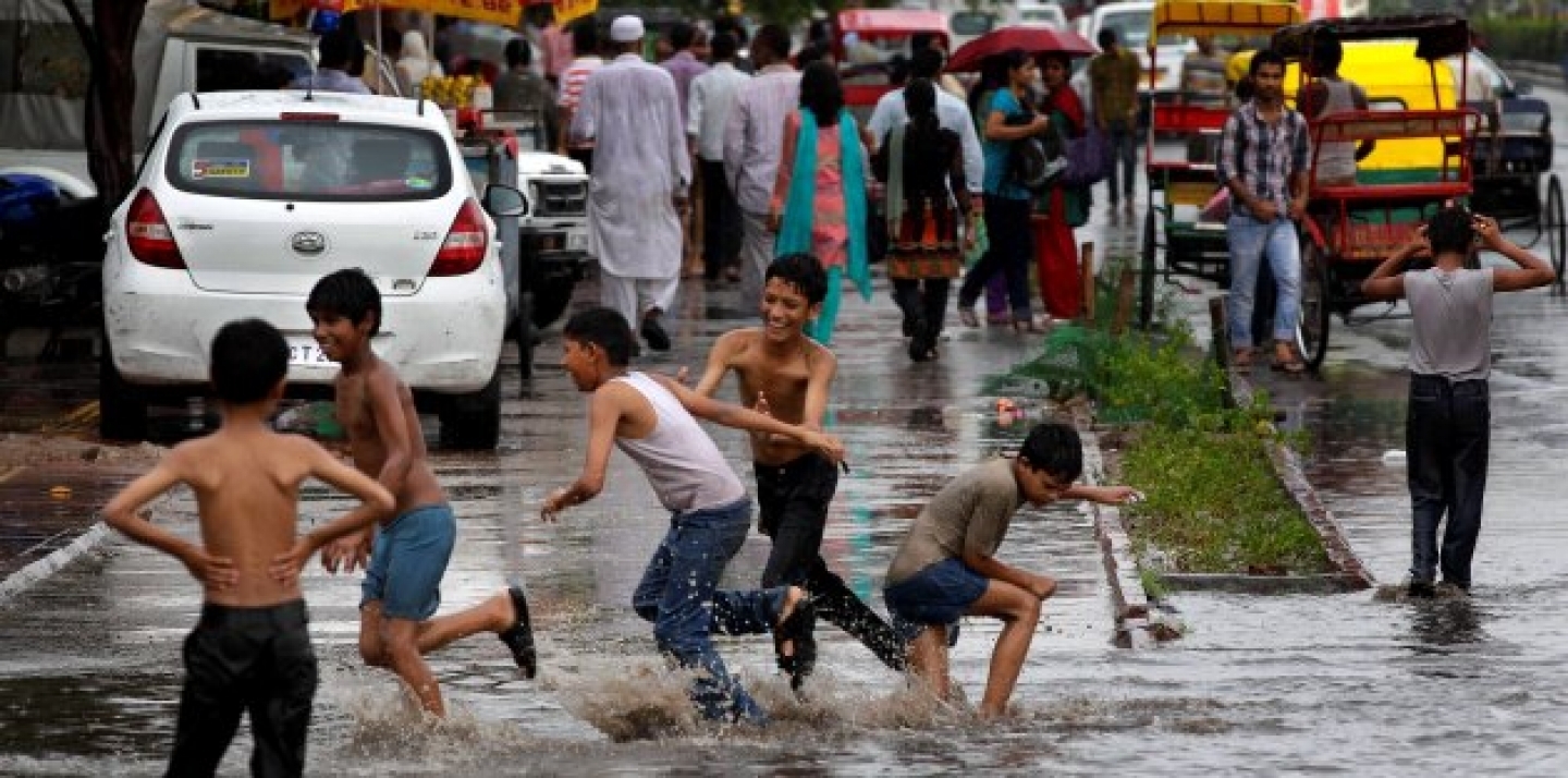 Children play in a water puddle left after a spell of rain in New Delhi, India. (AP Photo/Saurabh Das)