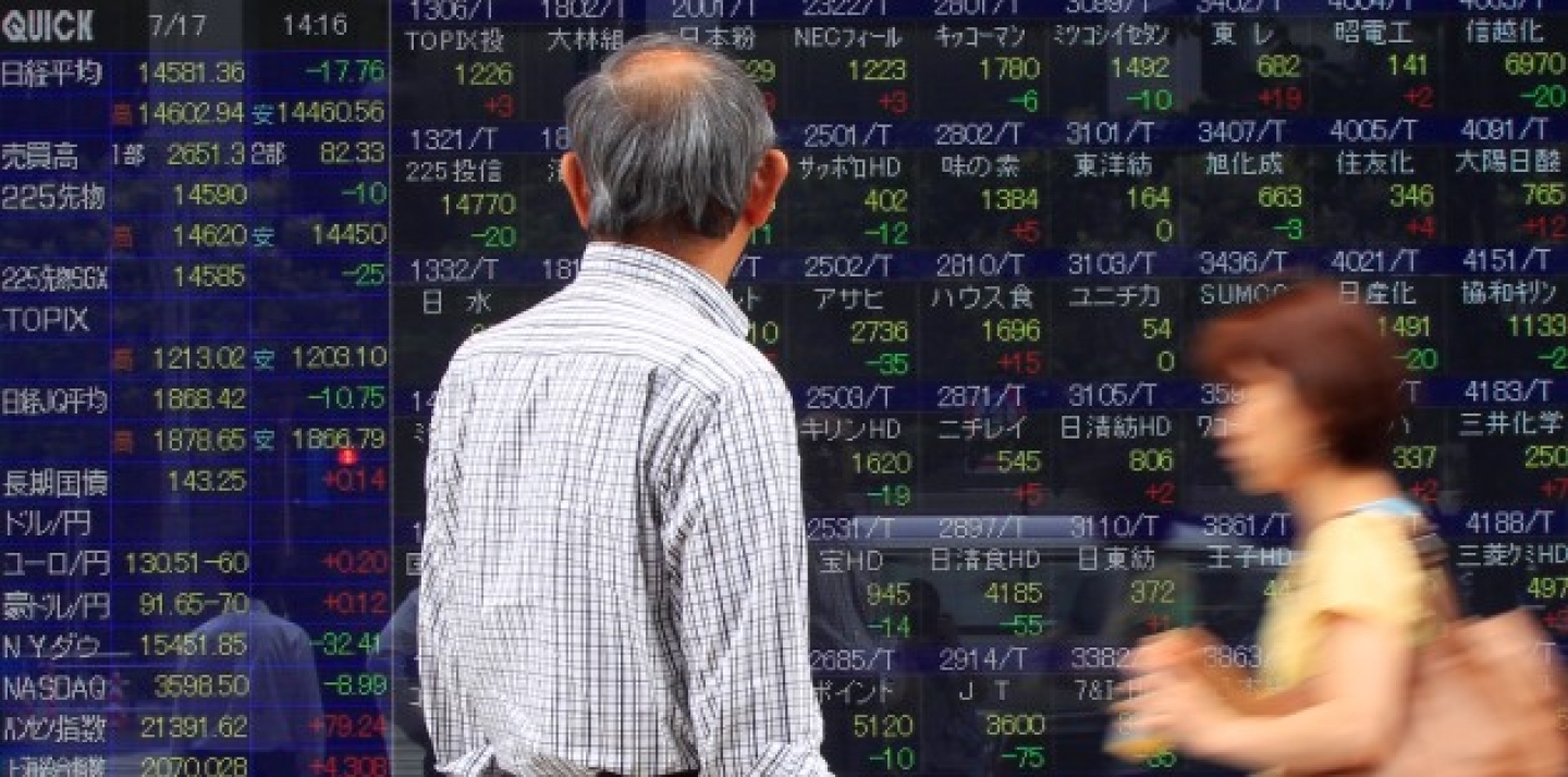 A man watches an electronic stock indexes in Tokyo, Japan, Wednesday, July 17, 2013. Asian stock markets were mixed Wednesday as investors remained cautious ahead of testimony from U.S. Federal Reserve Chairman Ben Bernanke. (AP Photo/Shizuo Kambayashi)