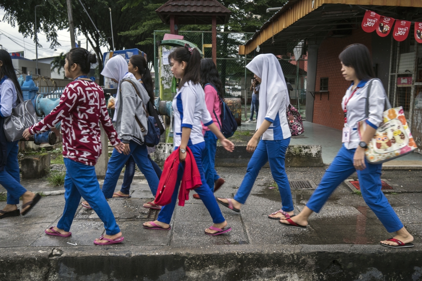 A group of young women migrant workers make their way to a nearby factory facility where they work in Petaling Jaya, Malaysia. (UN Women/Staton Winter)
