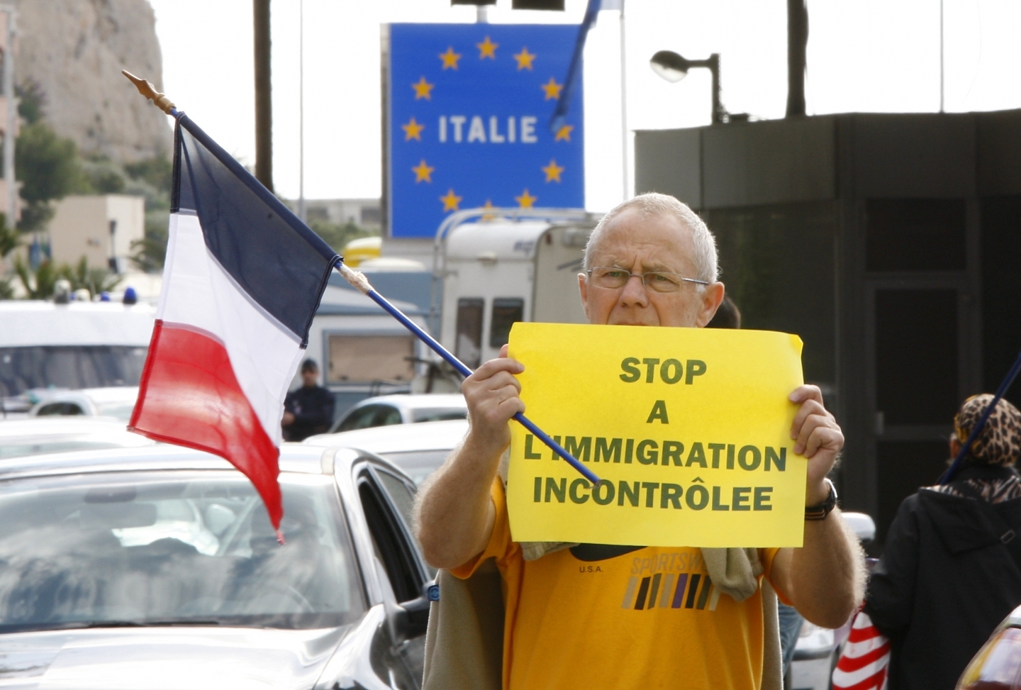 An unidentified French far-right National Front party demonstrator holds an anti-immigration sign (AP Photo/Antonio Calanni)