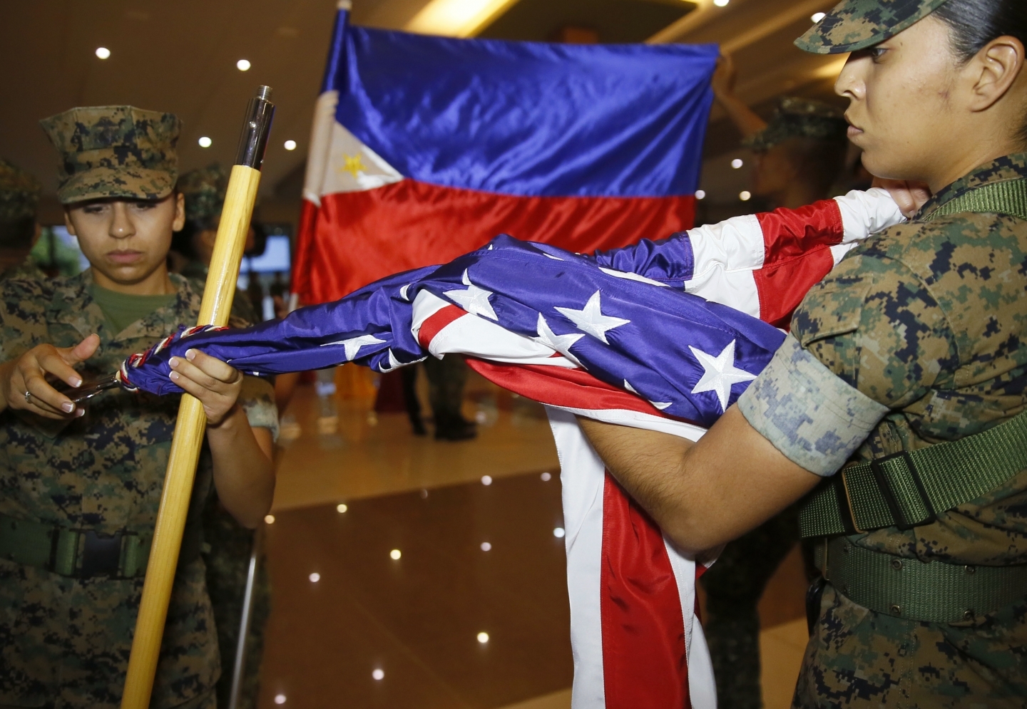 A U.S. Marine and her Philippine counterpart fold their flags near Manila on Oct. 11. Marines ended joint combat drills a day early after President Rodrigo Duterte criticized the U.S. (AP Photo/Bullit Marquez)