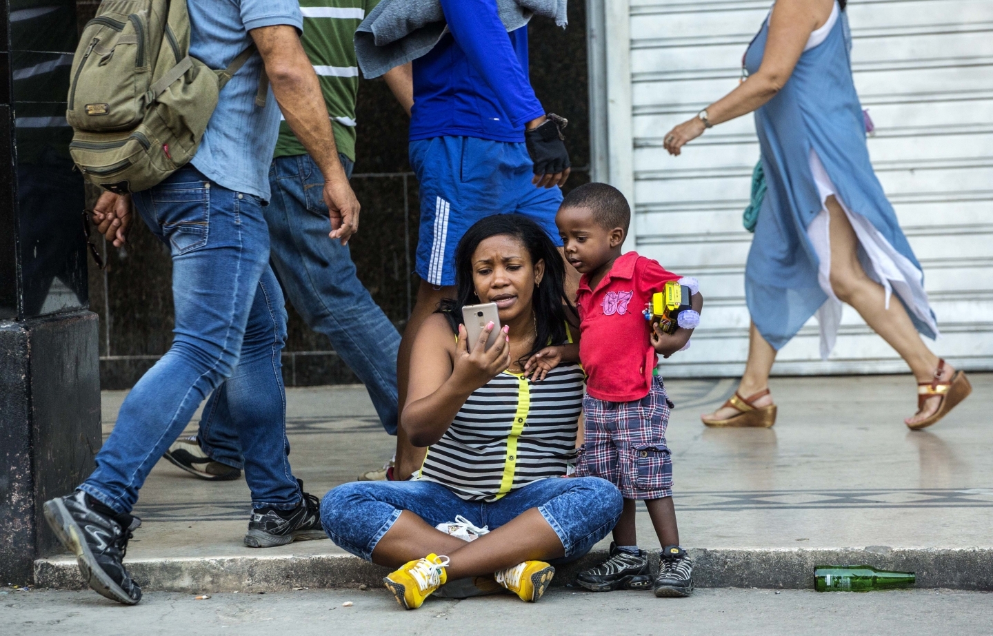 A woman with her child uses a public wifi hotspot in Havana, Cuba (AP Photo/Desmond Boylan)