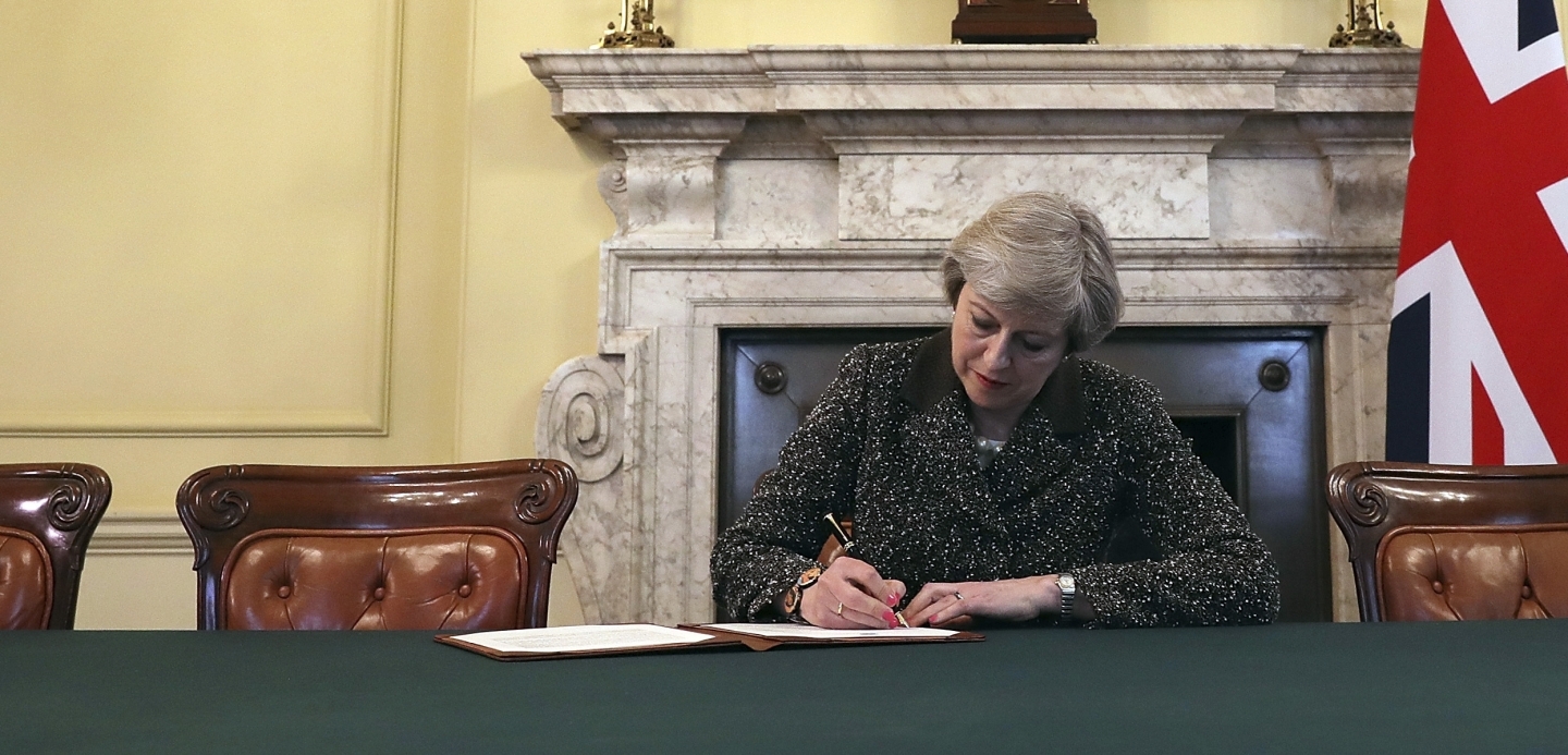 British Prime Minister Theresa May signs the official letter to European Council President Donald Tusk invoking article 50 (Christopher Furlong/Pool Photo via AP)