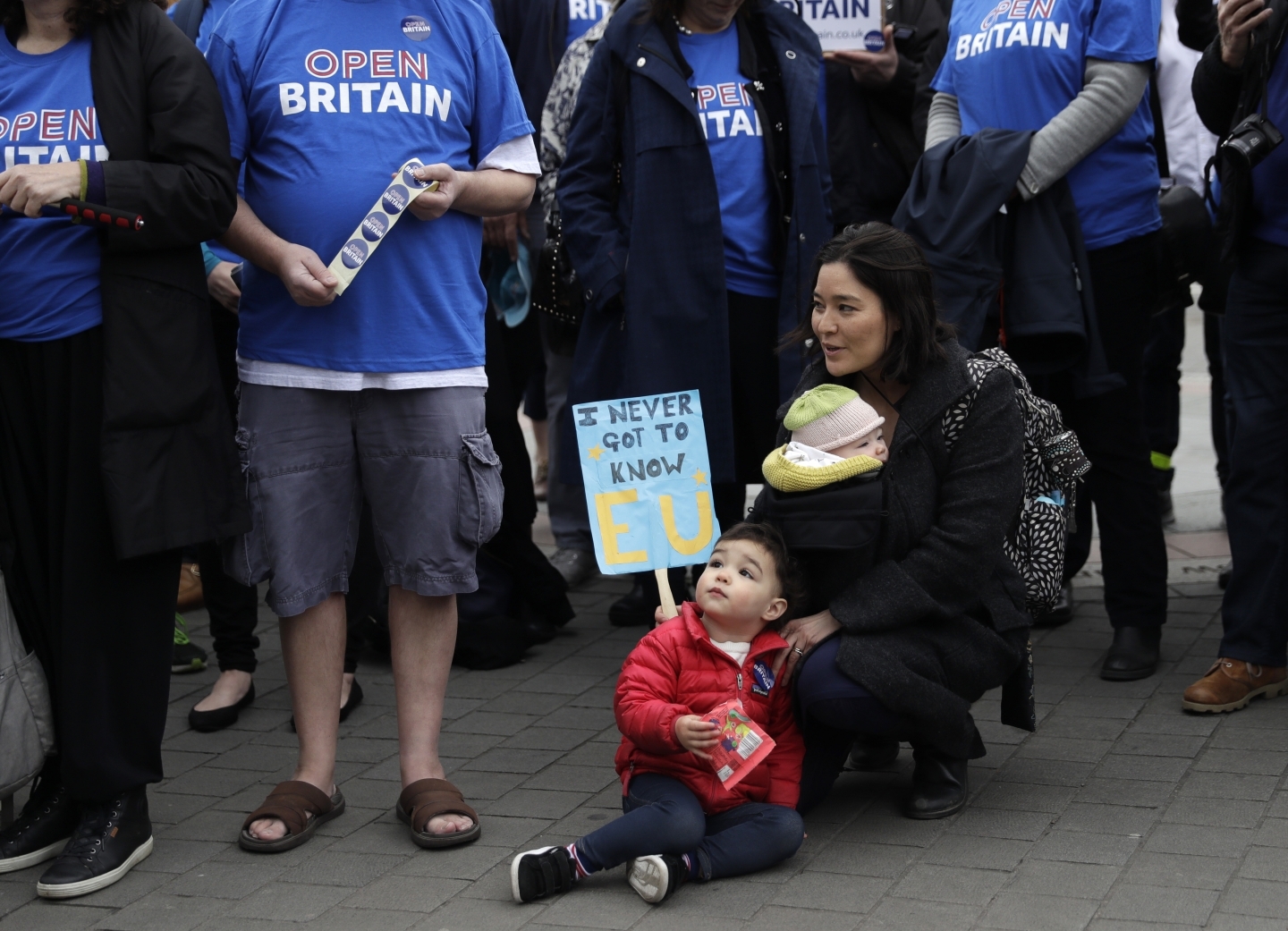 Protesters stand outside the House of Commons in London as Brexit negotiations begin (AP Photo/Matt Dunham)