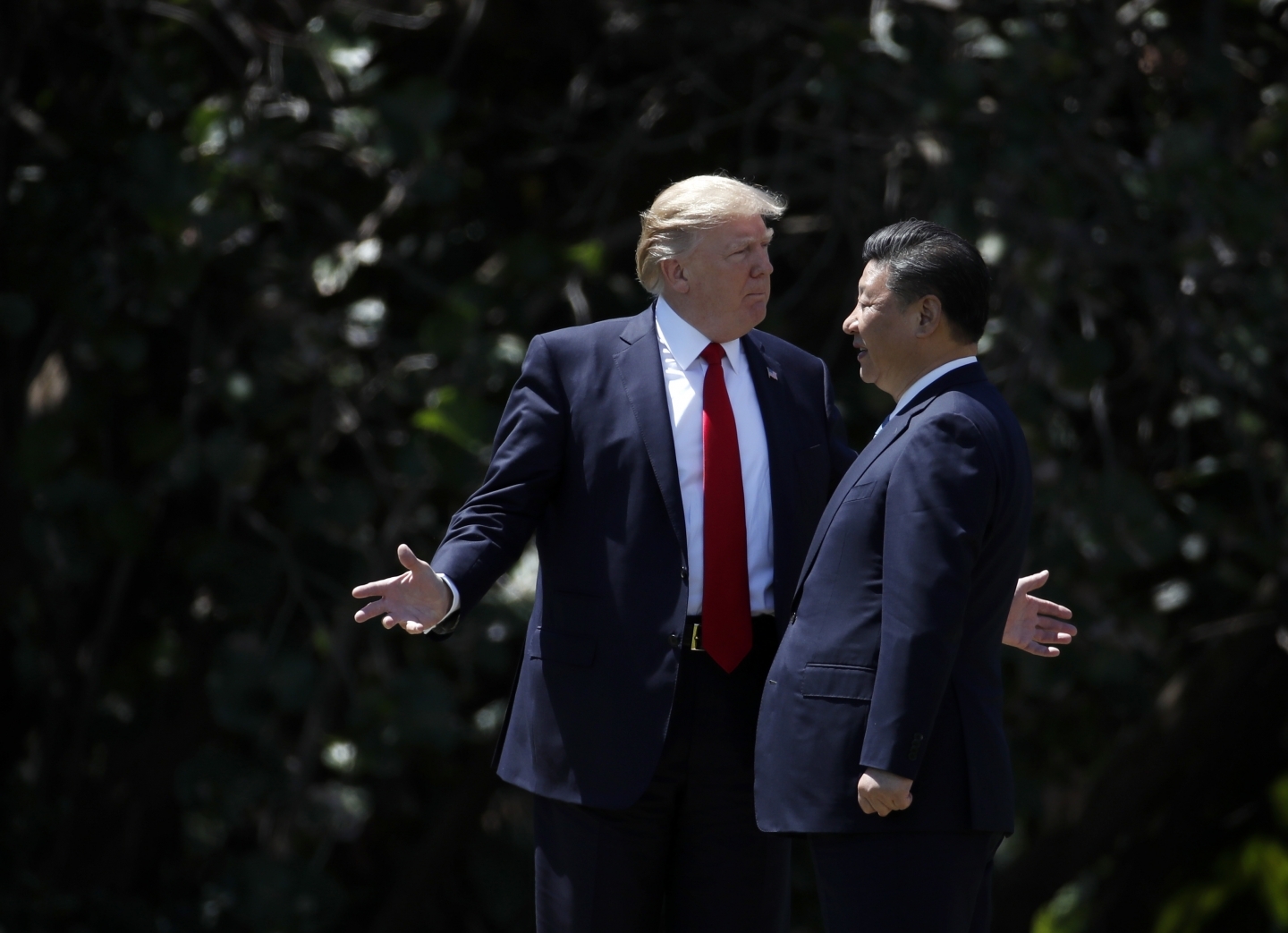 President Donald Trump gestures as he and Chinese President Xi Jinping walk together after their meetings at Mar-a-Lago, Friday, April 7, 2017, in Palm Beach, Fla. (AP Photo/Alex Brandon)