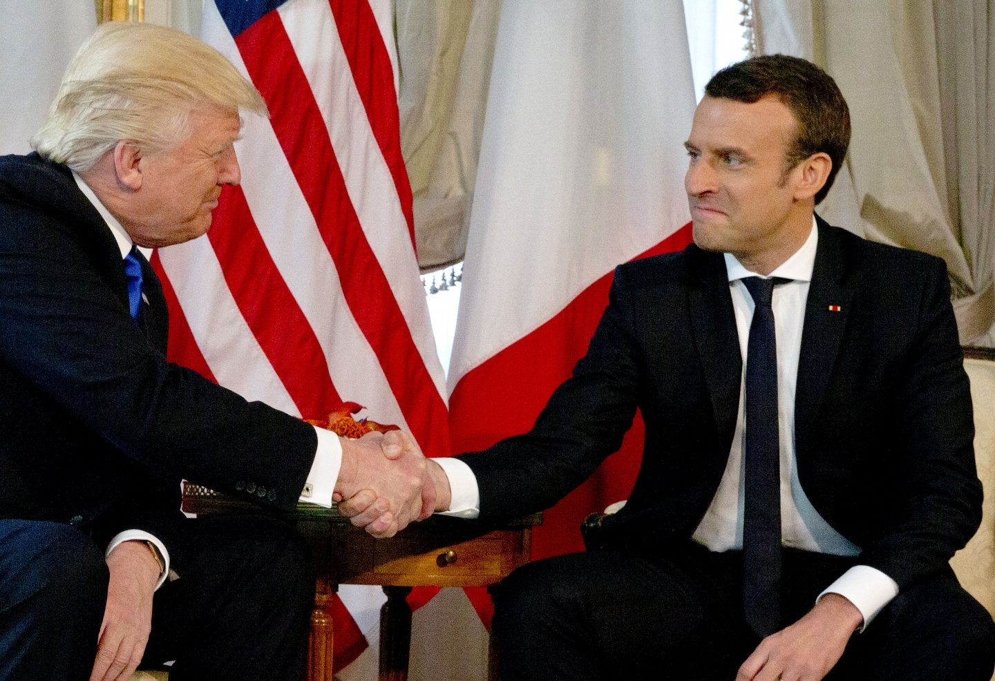 US President Donald Trump shakes hands with French President Emmanuel Macron (AP Photo/Peter Dejong, Pool)