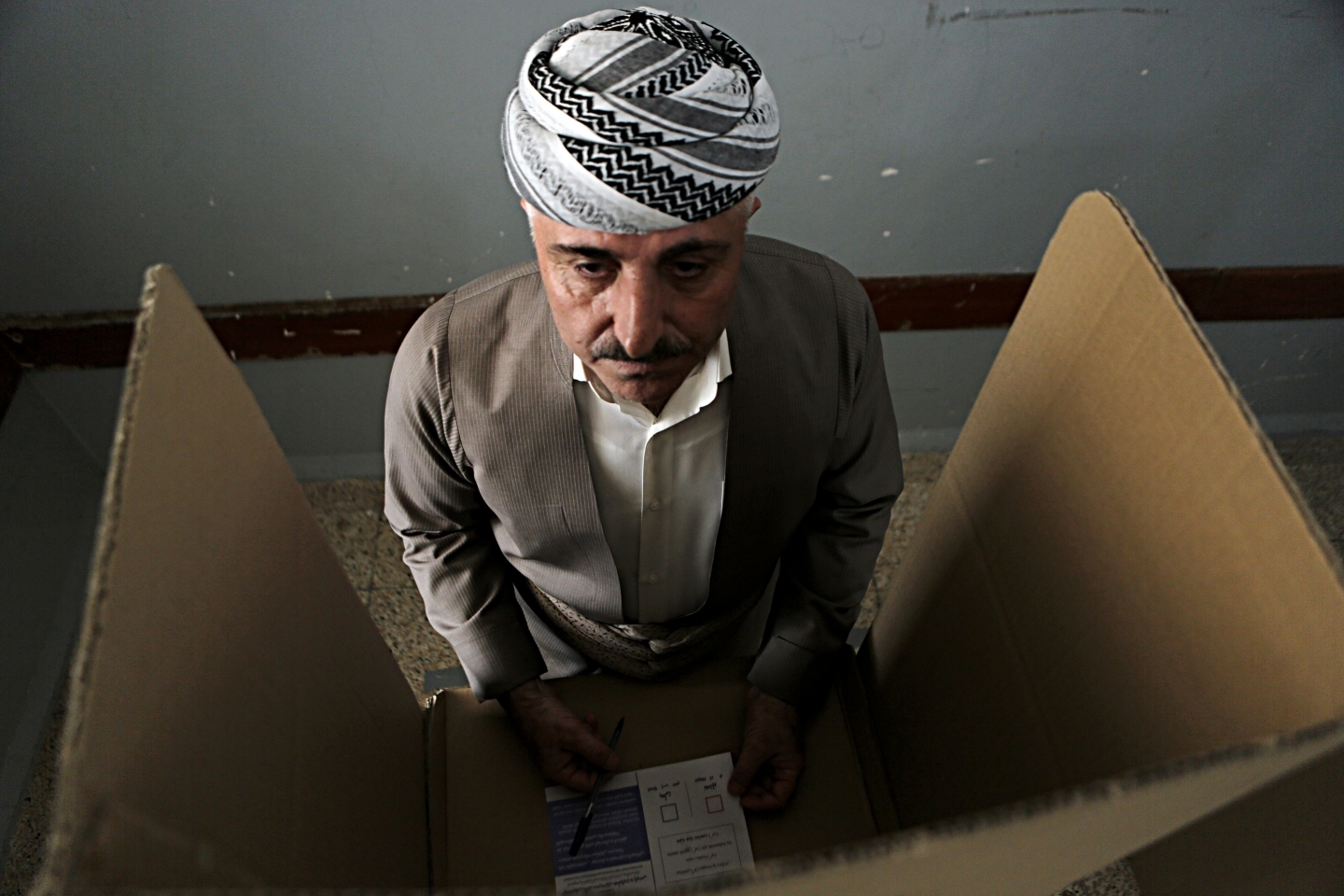 An Iraqi Kurdish man prepares to casts his ballot during the referendum on independence from Iraq in Irbil, Iraq, Monday, Sept. 25, 2017. (AP Photo/Khalid Mohammed)