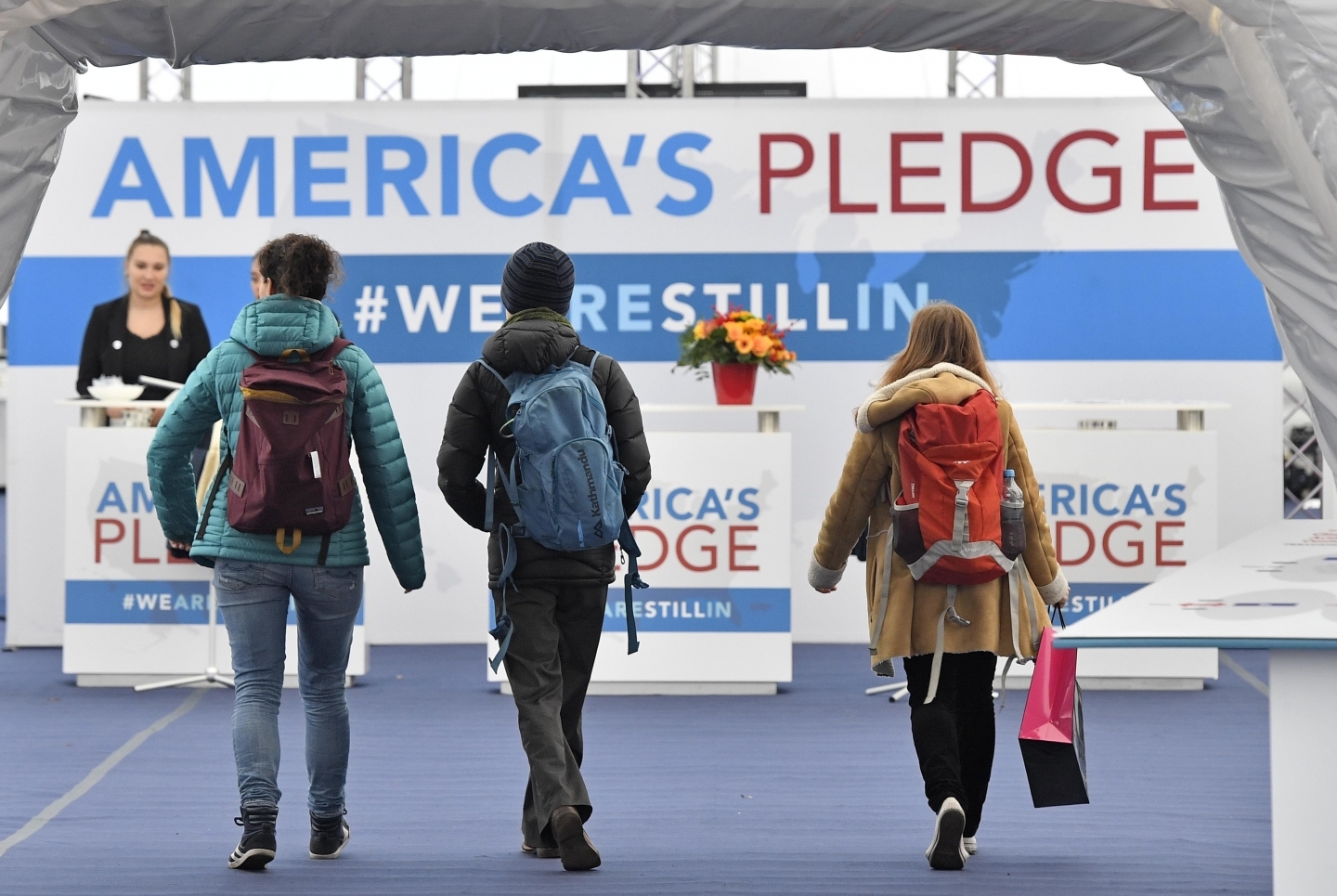 Visitors enter the US Climate Action Center at the COP 23 Fiji UN Climate Change Conference in Bonn, Germany, Thursday, Nov. 9, 2017. (AP Photo/Martin Meissner)