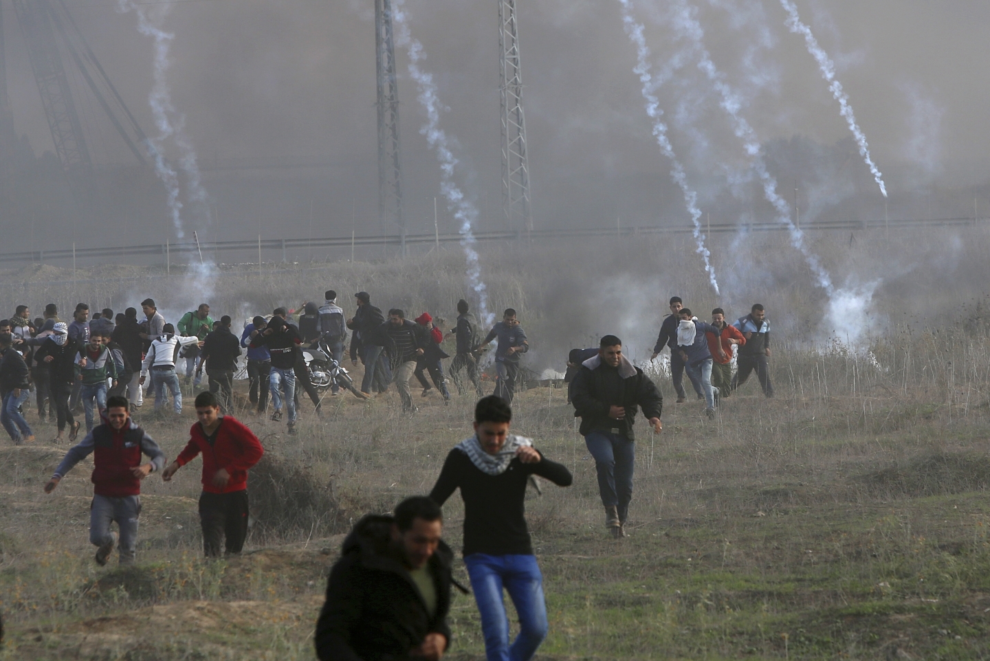 Palestinian protesters run from teargas fired by Israeli soldiers following the US decision to recognize Jerusalem as the capital of Israel. (AP Photo/Adel Hana)