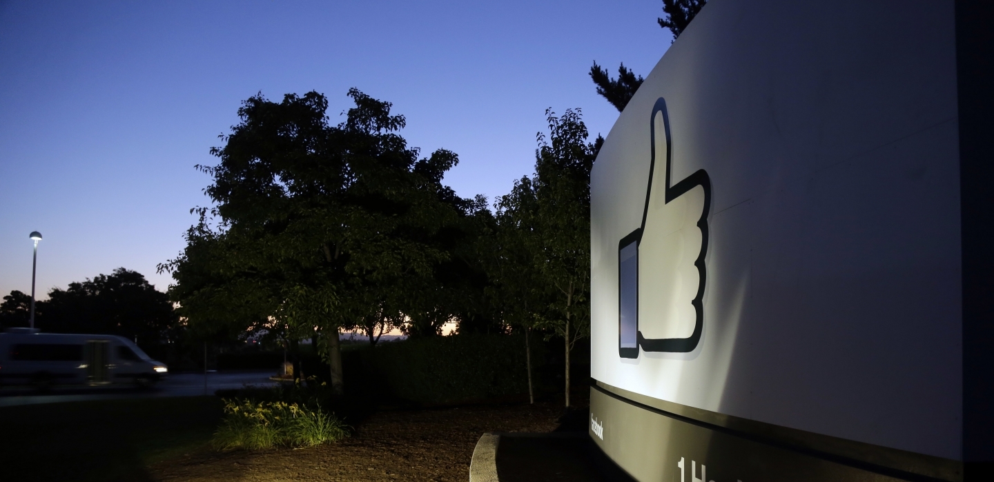 The Facebook "like" symbol is illuminated on a sign outside the company's headquarters in California. (AP Photo/Marcio Jose Sanchez)