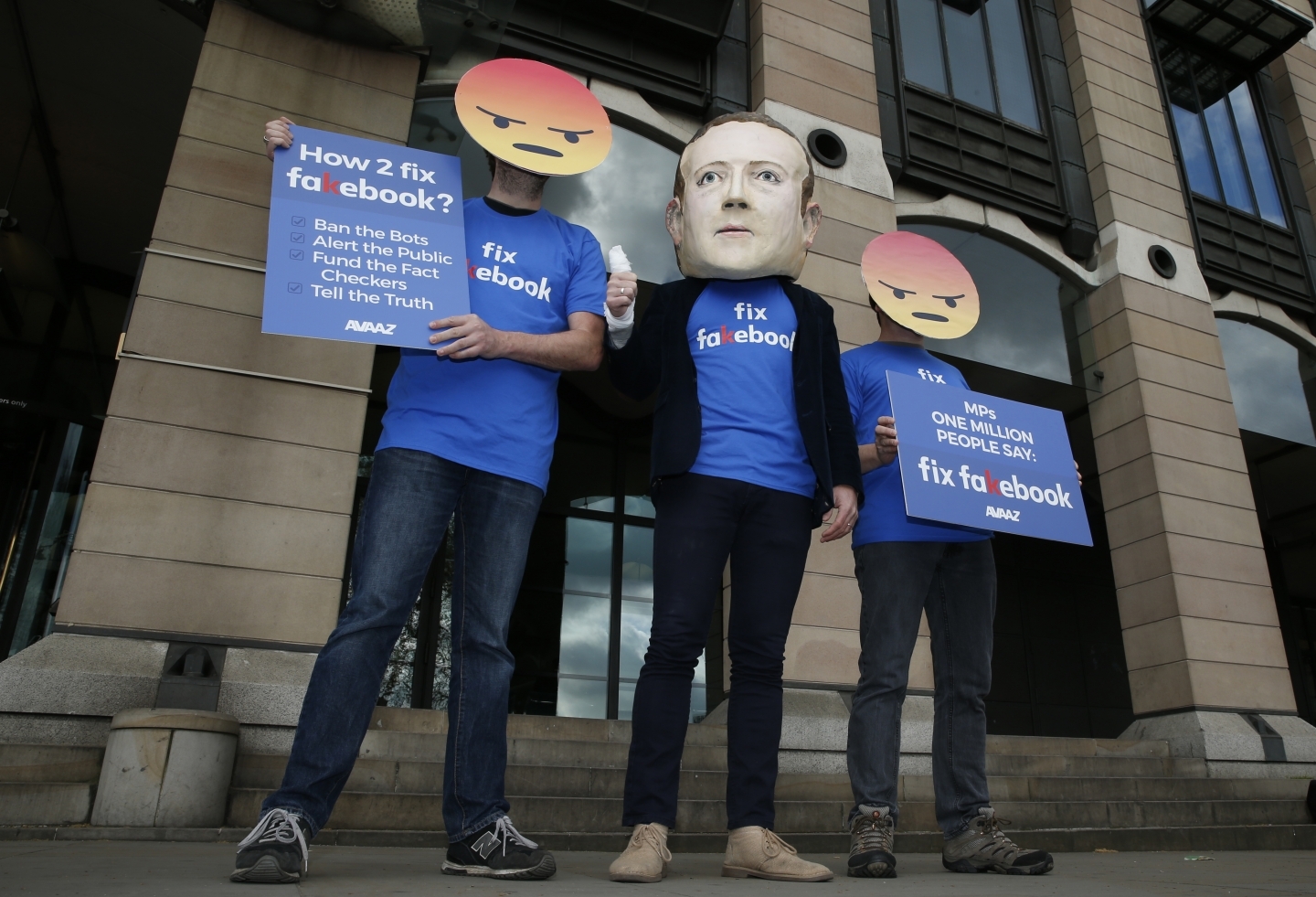 A protester wears a mask with the face of Facebook founder Mark Zuckerberg in London on April 26, 2018. (AP Photo/Alastair Grant)