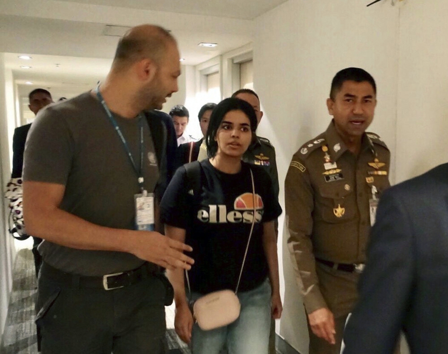 Rahaf Mohammed al-Qunun walks with immigration police before leaving the Suvarnabhumi Airport in Bangkok, Thailand on January 7, 2019. (Immigration police via AP, File)