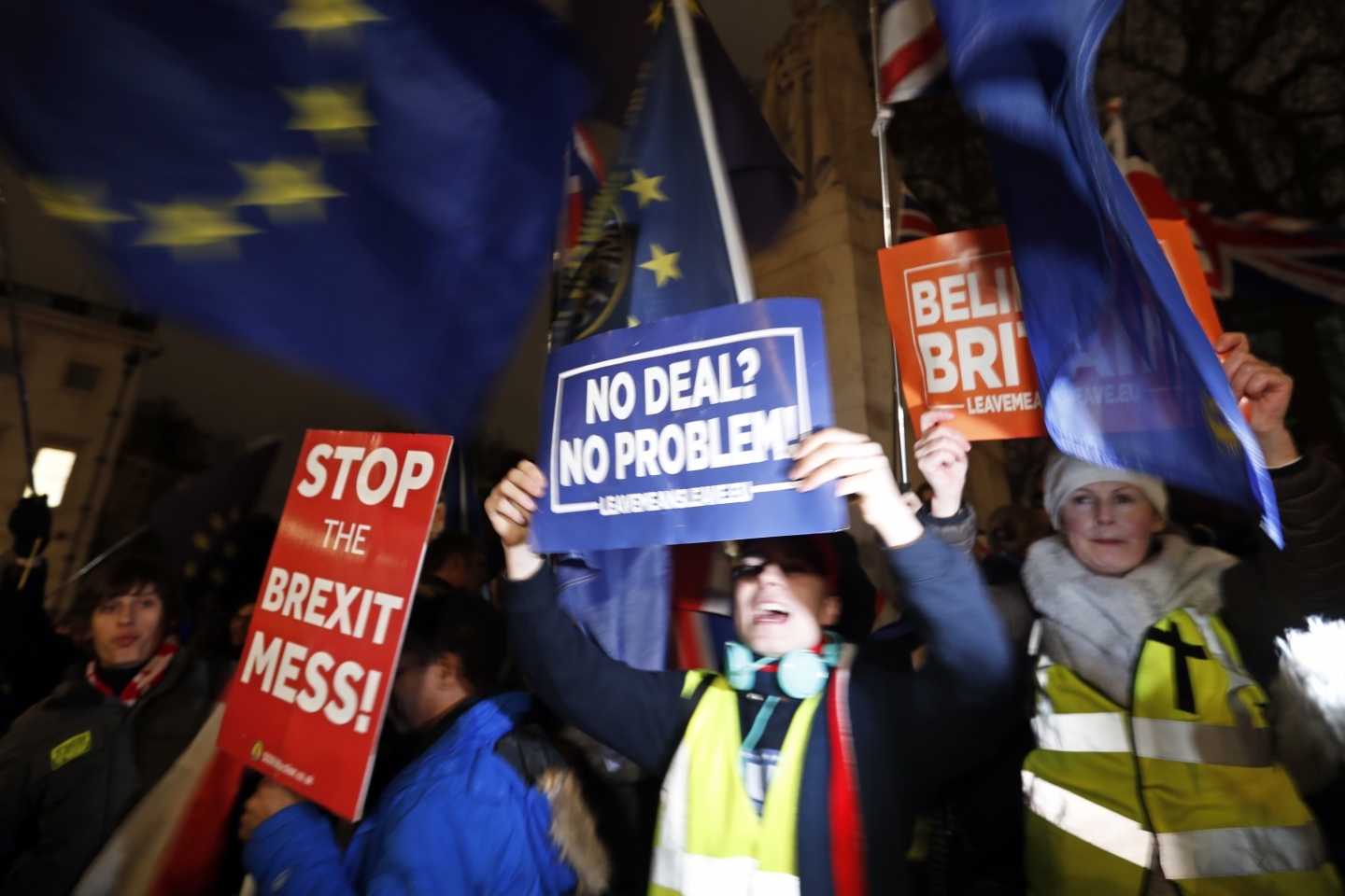 Protestors hold signs in Parliament Square in London, Tuesday, January 15, 2019. (AP Photo/Frank Augstein)