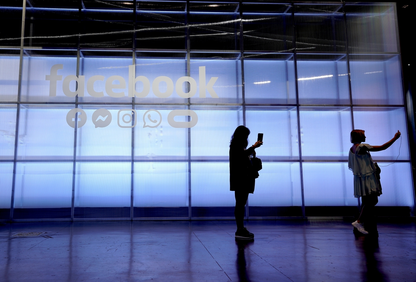 Attendees take a selfie in front of a Facebook sign at F8, the Facebook's developer conference on April 30, 2019. (AP Photo/Tony Avelar )